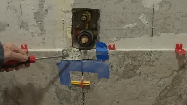 Chiseling tile mistake away from shower diverter - women