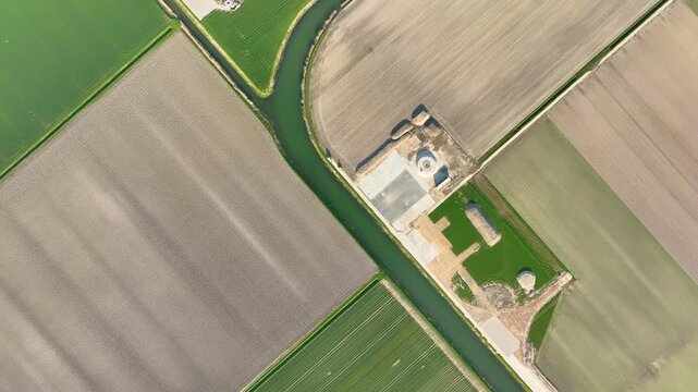 Aerial top down view of agricultural fields and irrigation canals. Geometric patterns of farmland and water channels from a drone. Concept of modern farming and irrigation.