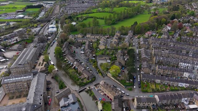 A slow forward drone flight over the Leeds and Liverpool Canal through Skipton, passing the railway station and tracks, with Aireville Park's green fields visible in the distance. North Yorkshire.
