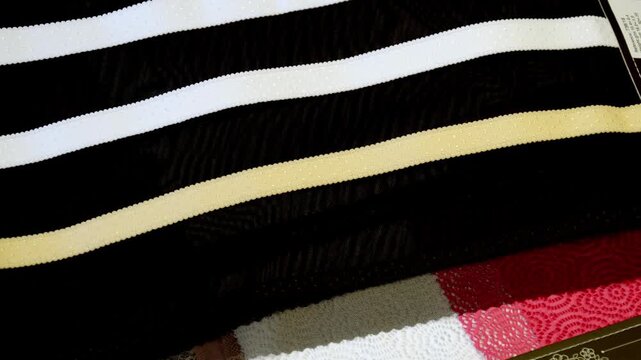 Various textile samples and fabric swatches displayed for selection. Fashion design and material sourcing process with different textures, colors and patterns.