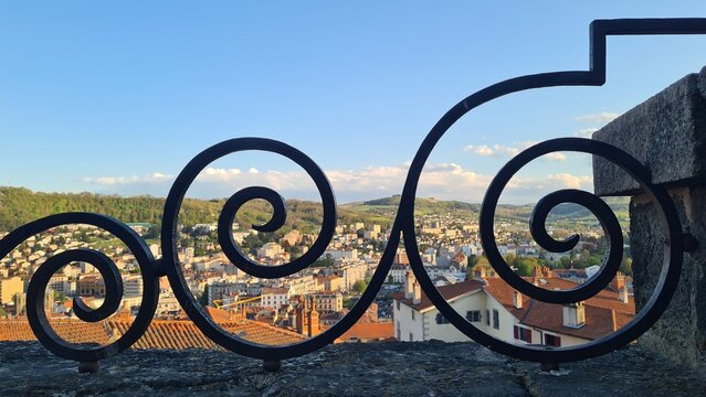 La basse ville du Puy-en-Velay vue depuis la Ville-Haute &agrave; travers les arceaux m&eacute;talliques de la place de la cath&eacute;drale (Auvergne)