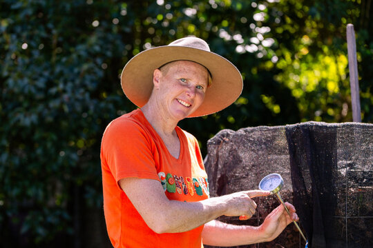 Female environmentalist checking temperature gauge on backyard compost pile