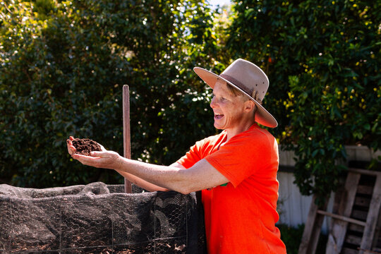 environmentalist composting advocate woman holding dirt made in garden compost system