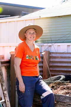 Australian woman in backyard garden ready to turn soil in compost container