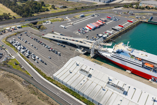 Aerial view of cars boarding a passenger ferry at a shipping terminal