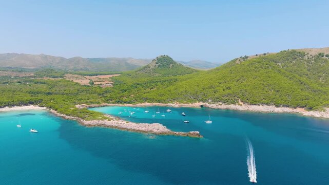 Aerial drone view of luxury yachts and boats in a turquoise bay with crystal clear water. Bright sunny summer landscape of a scenic coast and tropical beach.