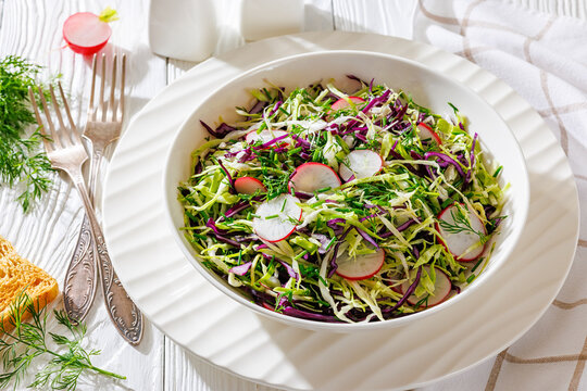 Fresh cabbage and radish coleslaw in white bowl