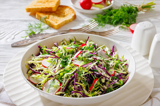 Fresh cabbage and radish coleslaw in white bowl