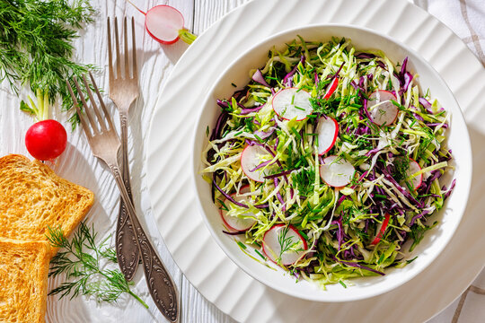 Fresh cabbage and radish coleslaw in white bowl