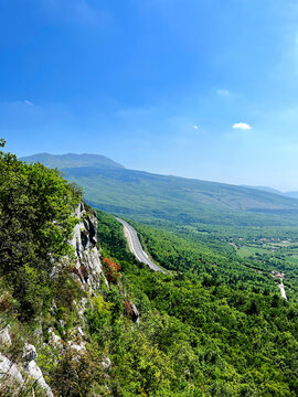 Scenic view of highway winding through green valley with Ucka mountain in background