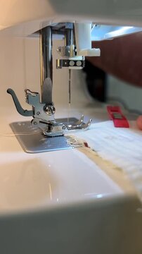 Macro video of sewing machine needle and presser foot working on soft double gauze textile.