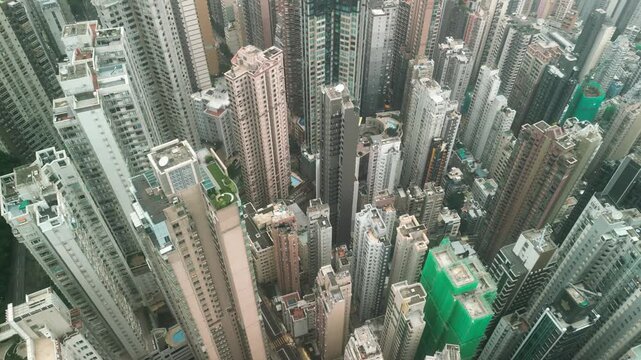 Aerial drone view of dense Hong Kong skyline with skyscrapers and harbor