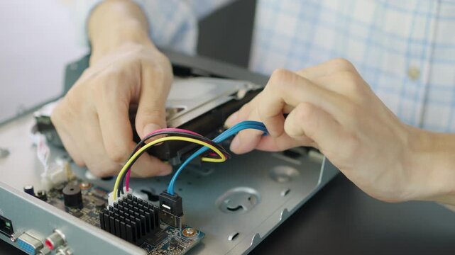 Hand of woman is installing a hard drive into a security camera recorder, Repairing a wireless CCTV camera