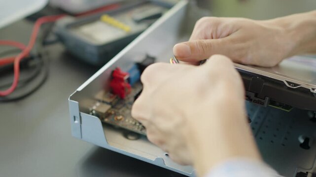 Hand of woman  remove a hard drive from a security camera recorder, Repairing a wireless CCTV camera