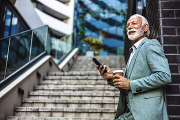 Obraz premium A cheerful mature man, enjoying his coffee, glances at his smartphone, capturing a joyful moment amid a busy urban setting infused with professionalism.
