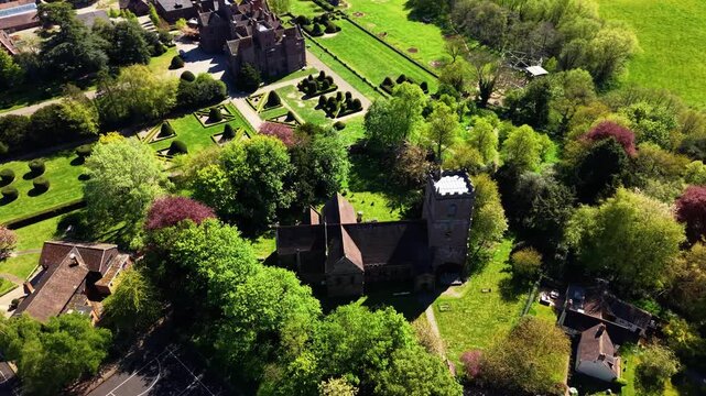 Drone orbiting and pulling back to reveal Condover Hall, medieval church, topiary gardens and green Shropshire countryside. Wide panoramic cinematic establishing shot.