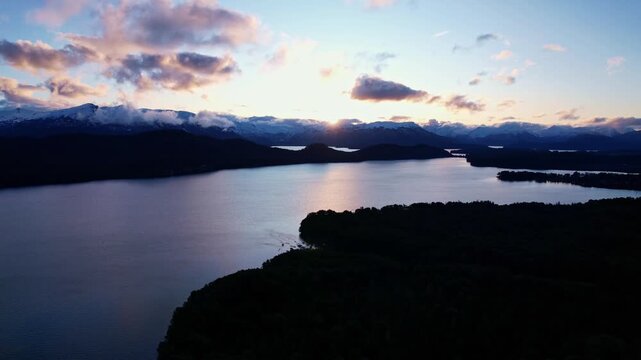 Aerial trucking shot of sunset over Nahuel Huapi Lake and Andean mountains in Patagonia Argentina