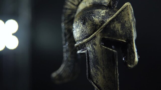 Slow motion 360 spin of wet gladiator helmet, bronze warrior armor cinematic close up