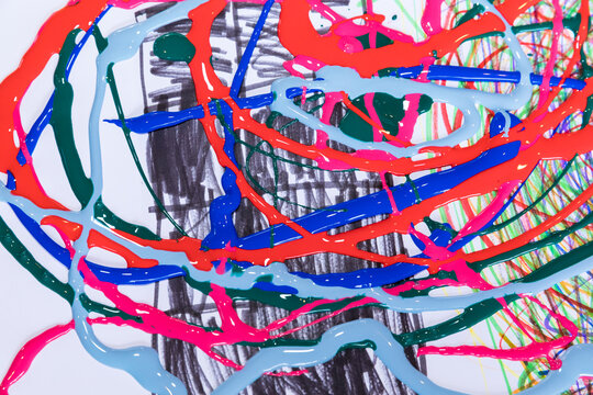 Child drawing with fluid acrylic polymer on white paper featuring expressive multi-color abstraction