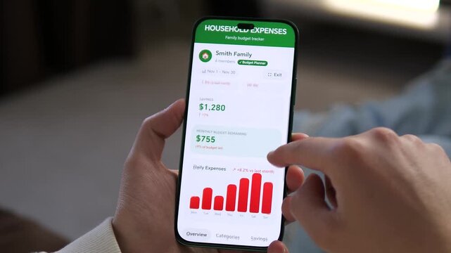 Detailed view of a budget planner app on a smartphone. User scrolls through daily expenses and savings data. Perfect for videos about smart money management, banking apps, and digital lifestyle trends