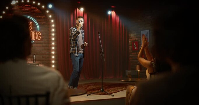 Male Comedian Closes a Live Stand-up Comedy Club Performance on Stage at an Open Mic Night, Telling Funny Jokes as the Audience Is Having Fun in a Bar Venue Entertainment Show Finale.