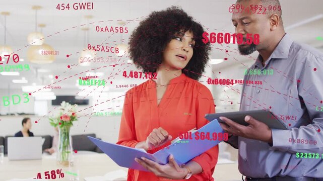 Woman reading folder, man tapping tablet causing crypto overlays crossing faces reviewing markets