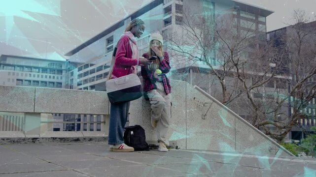 Two students sharing phone, one reacting and pointing, showing campus info with turquoise overlay