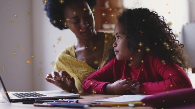 Mother using laptop, gesturing; child shifting gaze, asking; guiding homework with sparkles