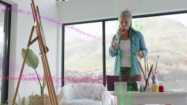 Artist woman checking phone for art reference using tablet sipping while animated swirls obscuring