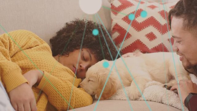Woman opening eyes and nudging puppy nose checking for pet care teal graphics sweeping across sofa