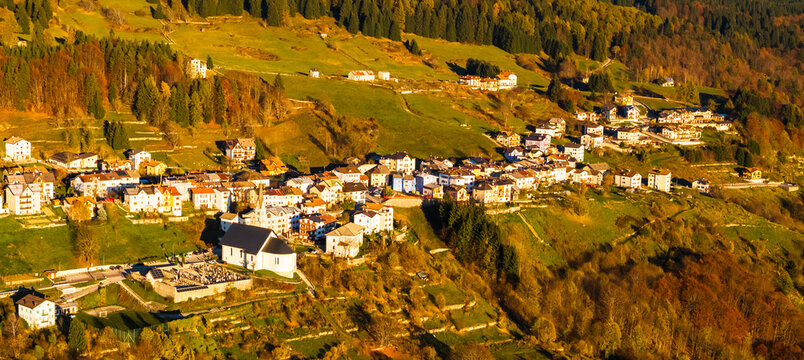 Mountain village nestled on a hillside with colorful autumn forests, showcasing a charming tourism destination in Luserna, Alpe Cimbra, Trentino, Italy.