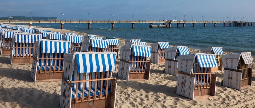 Strandk&ouml;rbe on Rugen beach lined in blue and white stripes facing Baltic Sea pier