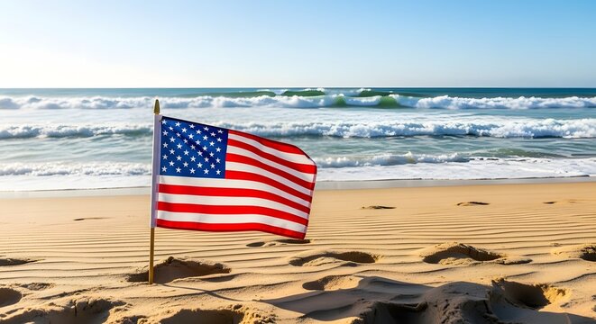 American flag waves on sandy beach on Independence Day by ocean