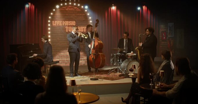 Trumpeter Leads a Live Jazz Band Playing on a Bar Stage During a Concert Event, Backed by Piano, Bass, Drums and Saxophone as the Audience Listens Closely to Each Song. Wide Shot of Fun Event