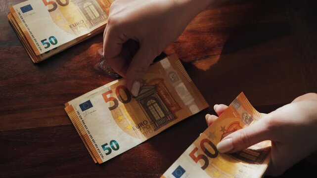 Hands of a woman counting many 50-euro bills. Woman counts banknotes salary or unemployment benefit. High quality 4k footage