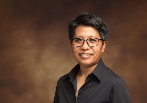 Short-haired woman smiling portrait in studio background
