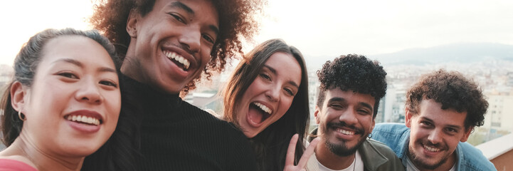 Obraz premium Close-up of young people standing on the balcony taking selfie on mobile phone. Panoramic