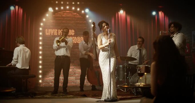 Portrait of a Female Singer Performing a Live Jazz Song at a Bar Concert Event, Sing on Stage With Band Playing Piano, Trumpet, Bass, Drums and Sax for the Audience in a Stylish Night Club.