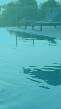 Vertical video: Pool water taking corner drop making ripples bending yellow digits for design