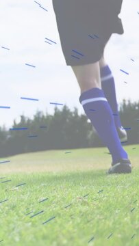 Vertical video: Soccer player kicking ball causing blue streaks, jogging away on field to move ball