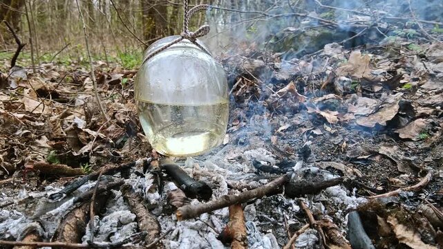  Improvised cooking using a glass jar over a dakota fire pit in the wild forest