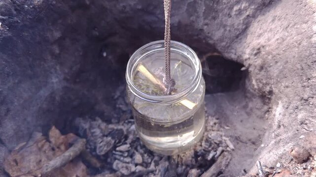 Boiling water in a glass jar over a dakota fire pit, survival lifehack