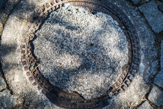 Rusty Metal Manhole Cover Set In Concrete Pavement Urban Infrastructure Detail