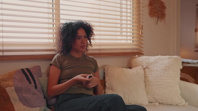 Smiling Woman Relaxing At Home Watching TV