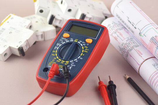 The digital multimeter electrical engineering drawings, circuit breaker and pencils.