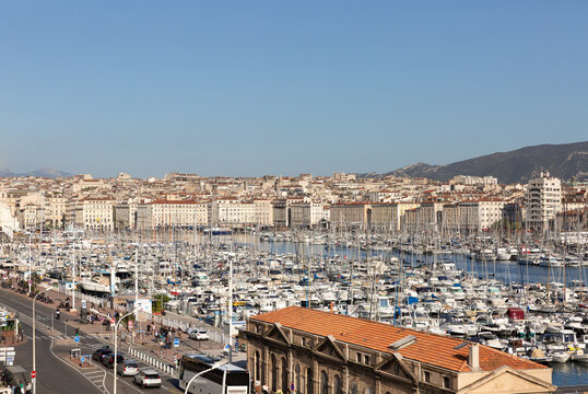 Panorama sur le Vieux Port de Marseille, vue depuis la sortie du port vers la ville, bateaux &agrave; quai, b&acirc;timents et ciel bleu en arri&egrave;re-plan