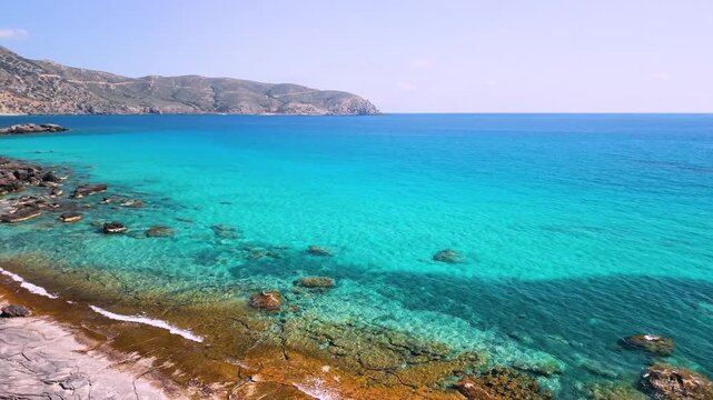 Aerial drone flight along Kedrodasos beach shoreline with turquoise water. Empty wild beach in Crete with crystal clear sea and rocks under water. Deserted paradise coast in Greece, 4k video.