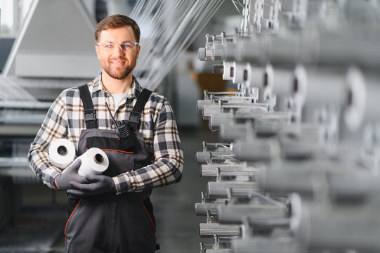Factory worker holding polypropylene yarn spools in textile production