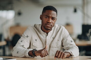 Obraz premium Young man giving thumbs up approval in office workspace