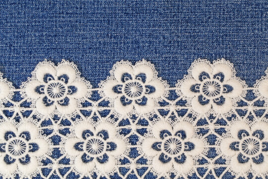 Lace pattern on denim cloth showing floral design, used for sewing projects and crafts